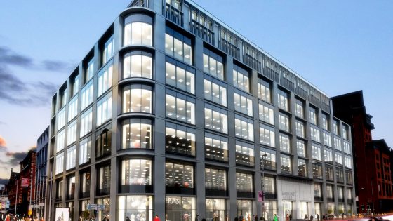 Image mock up of the exterior of a large scale building with cars and people outside of the building.