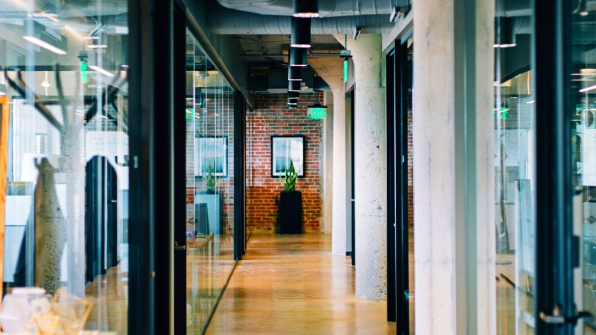 A high-end office corridor with glass partition walls.